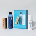 Collection of cleaning products including bottles, a brush, and a box on a light gray background