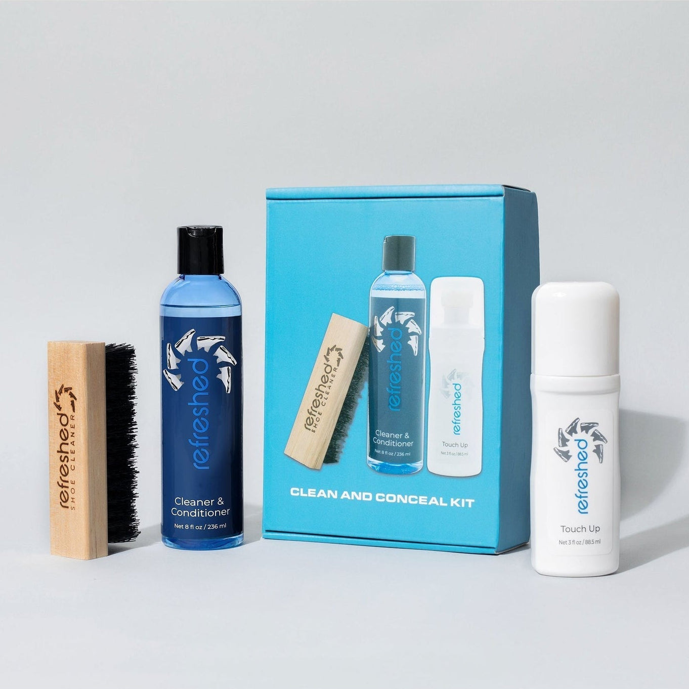 Collection of cleaning products including bottles, a brush, and a box on a light gray background